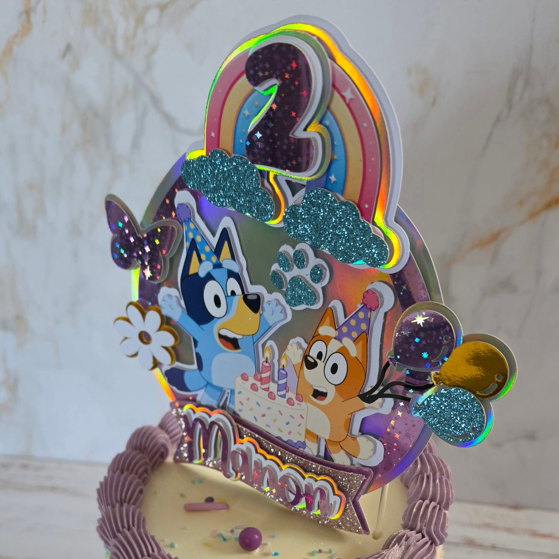 Topper cake 3D personnalisé Bluey pour gâteau d'anniversaire, décoration de gâteau sur mesure avec prénom, âge et thème personnalisé. Topper en impression 3D réalisé par Sweets Factory à Saint-Alban, près de Toulouse (31), pour anniversaires, baptêmes, mariages, baby showers et autres événements. Retrait sur commande.